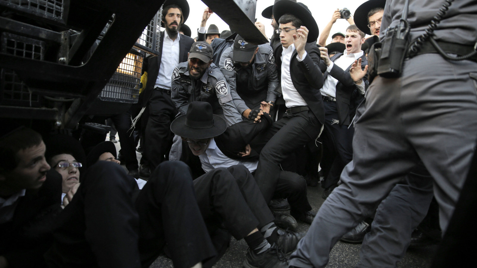 Ultra Orthodox Jewish youth scuffle with Israeli police officers during a protest against their enlistment in the army at the entrance to Jerusalem,, Oct. 23, 2017. (AP/Sebastian Scheiner)