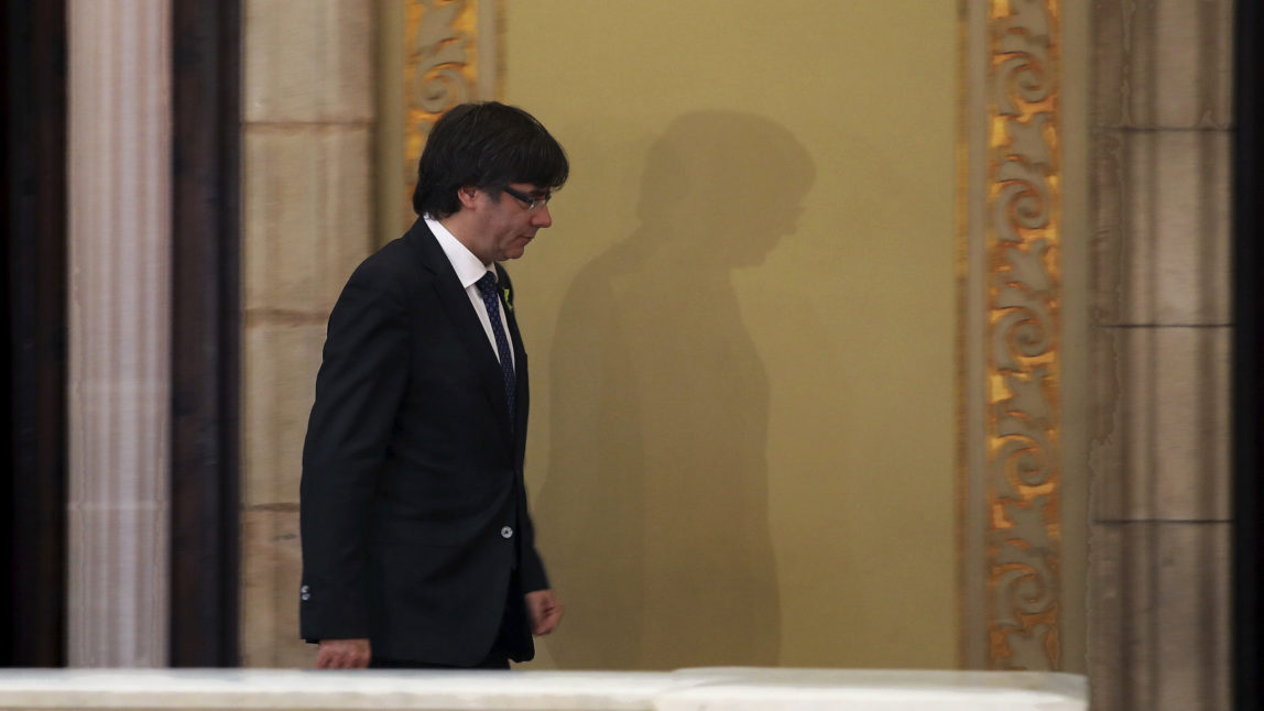 Catalan President Carles Puigdemont walks after his arrival inside the Catalan parliament in Barcelona, Spain, Friday, Oct. 27, 2017. Catalonia's parliament on Friday will resume debating its response to the Spanish government's plans to strip away its regional powers to halt it pushing toward independence.(AP Photo/ Emilio Morenatti)