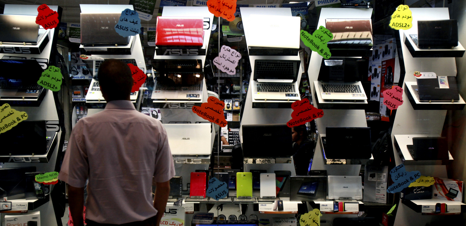 A young Iranian man browses a display of laptop computers for sale at a shop in Tehran, Iran. (AP/Ebrahim Noroozi)