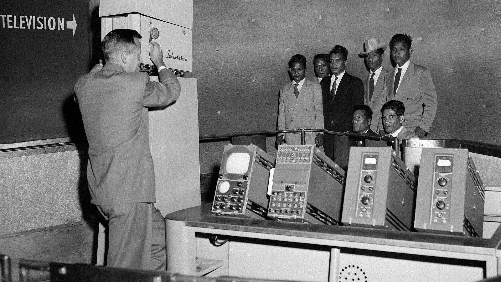 Six tribesmen from remote Pacific Islands are televised at the Museum of Science and Industry exhibit where they can see themselves in Chicago on April 7, 1957. The six were exposed to radioactive fallouts from the 1954 hydrogen explosion at Bikini, and have been brought to Chicago for tests. (AP Photo/EM)