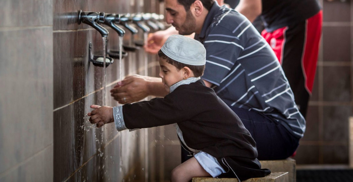 A father and son wash before prayer at a mosque in Jordan. Water usage at mosques is an issue imams are tackling. (Credit: GIZ)
