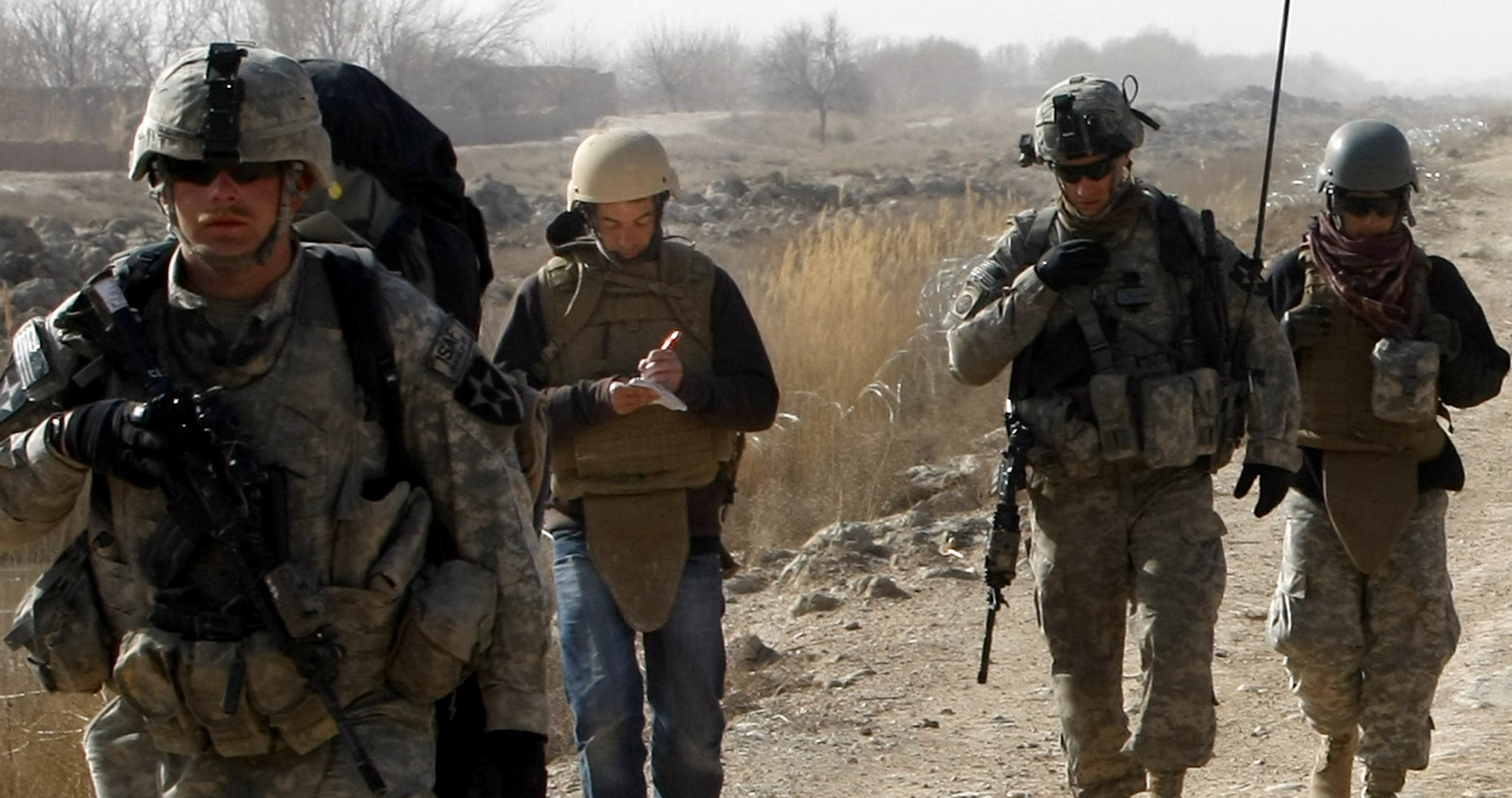 Associated Press reporter Chris Torchia takes notes as he walks with U.S. soldiers during a patrol in the Badula Qulp area in Helmand province, Afghanistan, Feb. 15, 2010. (AP/Pier Paolo Cito)