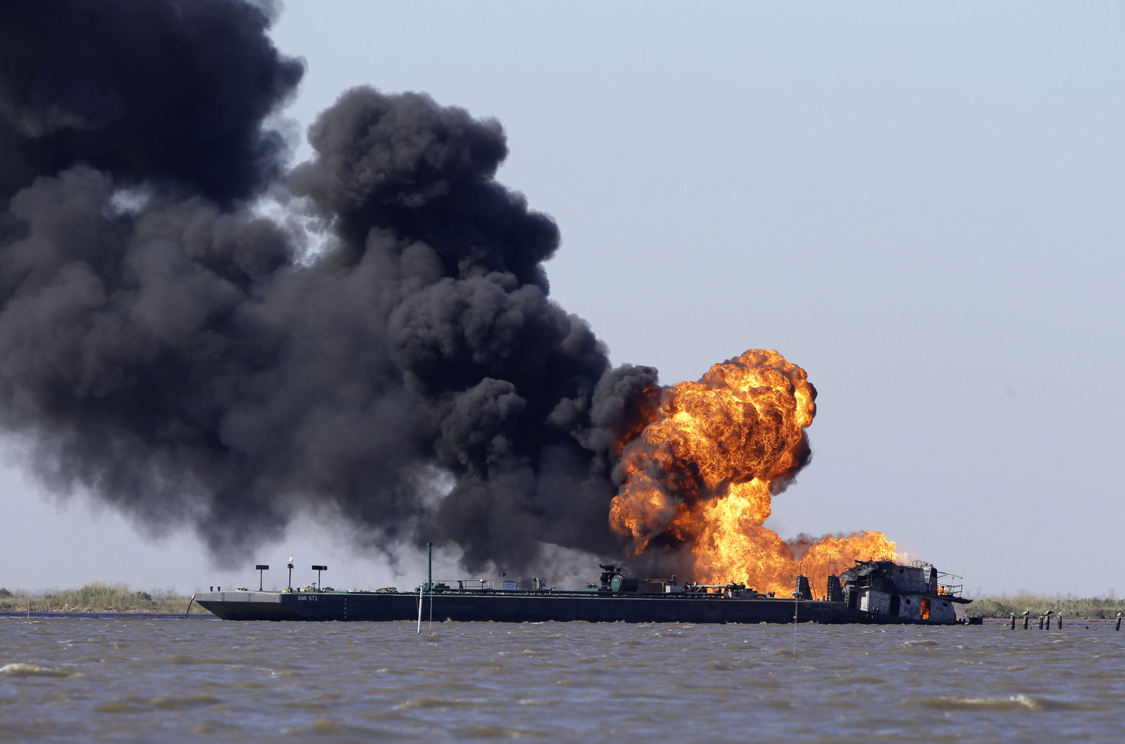 A fire burns after a tugboat and barge hit a gas pipeline in Perot Bay in Lafourche Parish, La., March 13, 2013. (AP/Gerald Herbert)