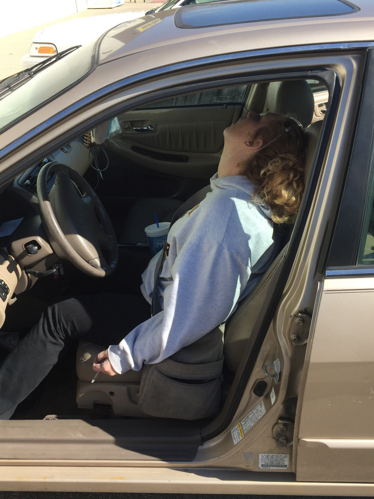 Erika Hurt sits with her baby in the back seat of the car in Hope, Ind. Police said she appeared unresponsive from an overdose and had a syringe in her hand. (Town of Hope PD/AP)