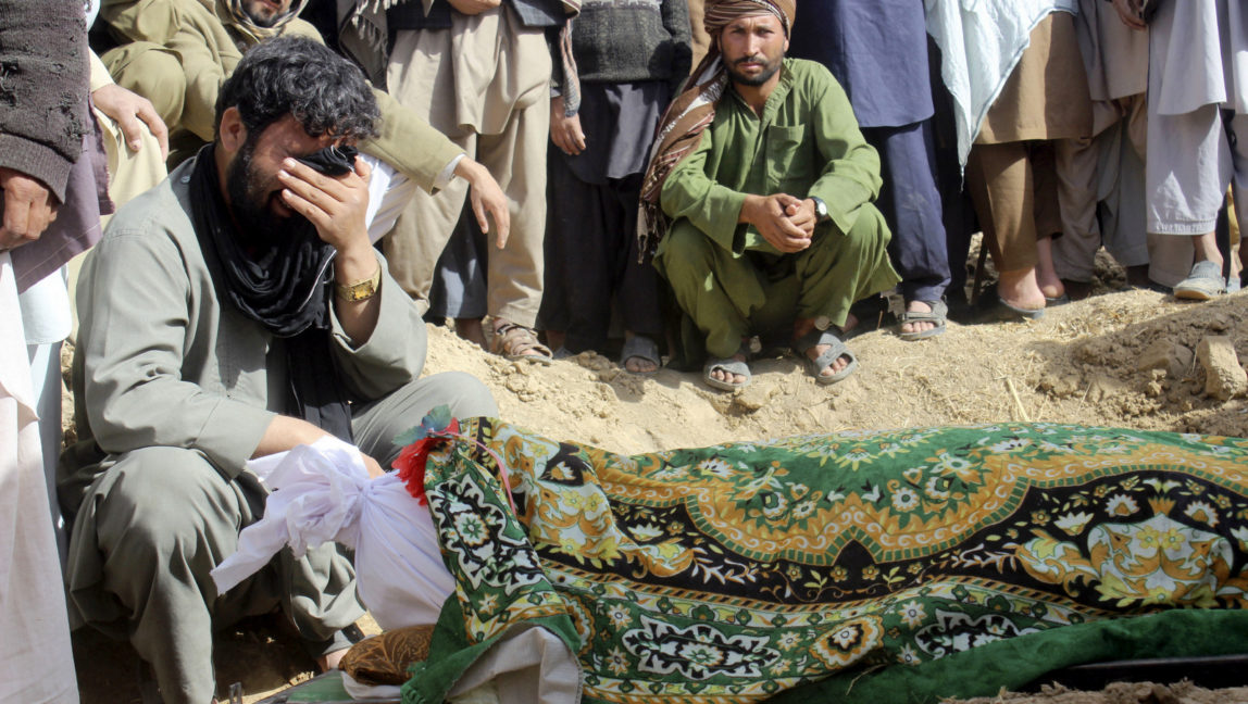 Afghan villagers gather around a victim who was killed during clashes between Taliban and Afghan security forces in Taliban's controlled village, Buz-e Kandahari village in Kunduz province, north of Kabul, Afghanistan, Nov. 4, 2016. (AP/Najim Rahim)