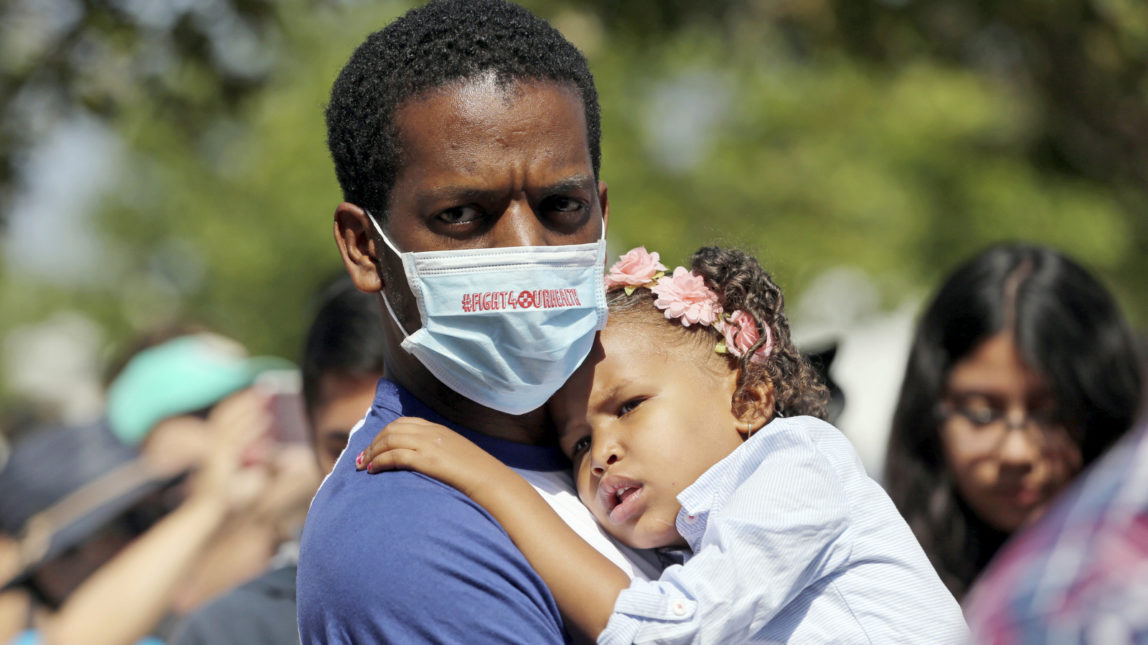 Anthony Reese, who says he is homeless, holds his daughter Makailei Pratt, 3, at a rally led by U.S. Sen. Kamala Harris, D-Calif., with doctors, nurses, health care workers and patients who will lose access to health care or see costs rise, at Harbor-UCLA Medical Center in Torrance, Calif., July 3, 2017. (AP/Reed Saxon)