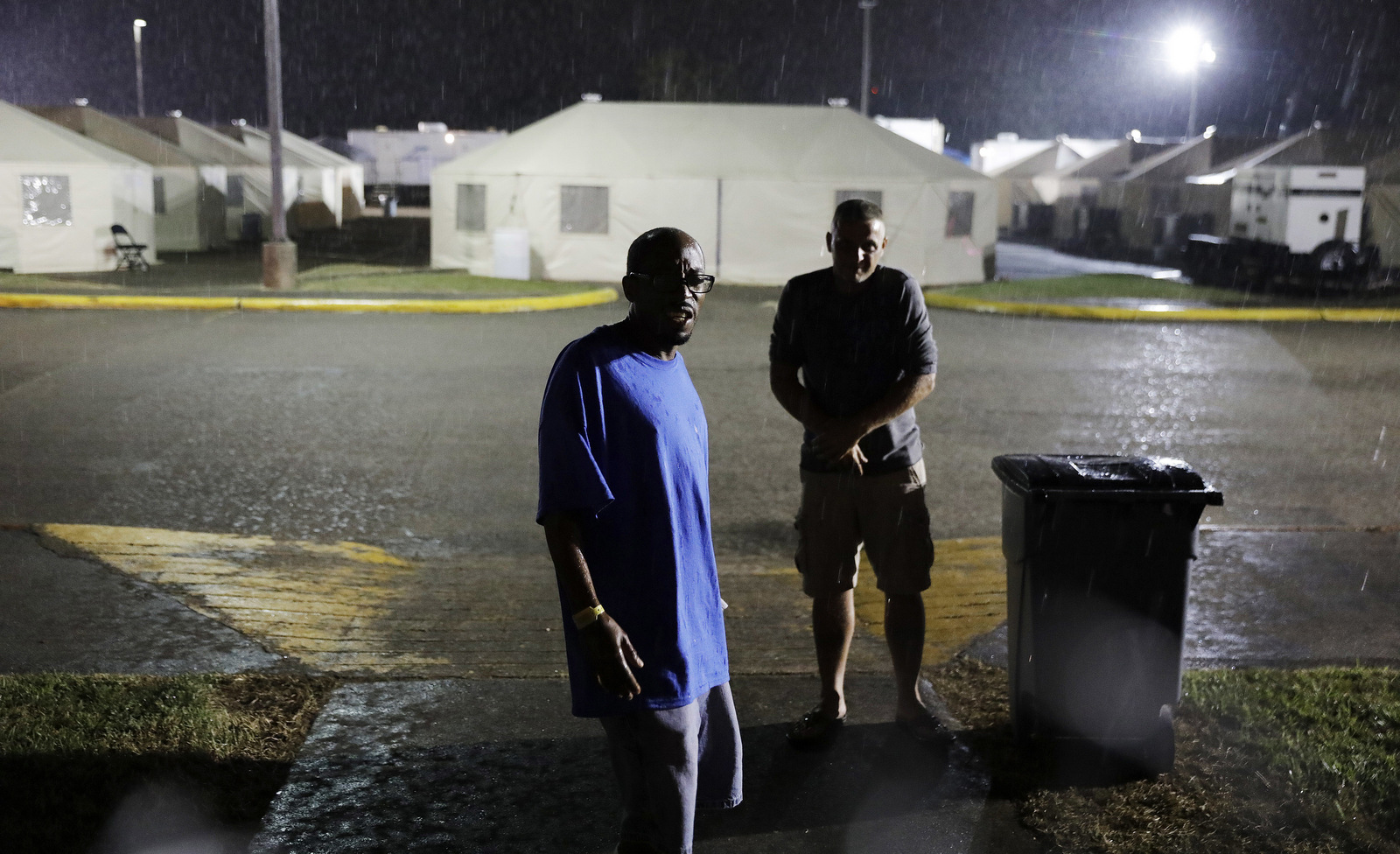 Arthur Shields, left, and a fellow evacuee walk through a temporary shelter encampment in Port Arthur, Texas where they've been living since hurricane Harvey damaged their homes. (AP/David Goldman)