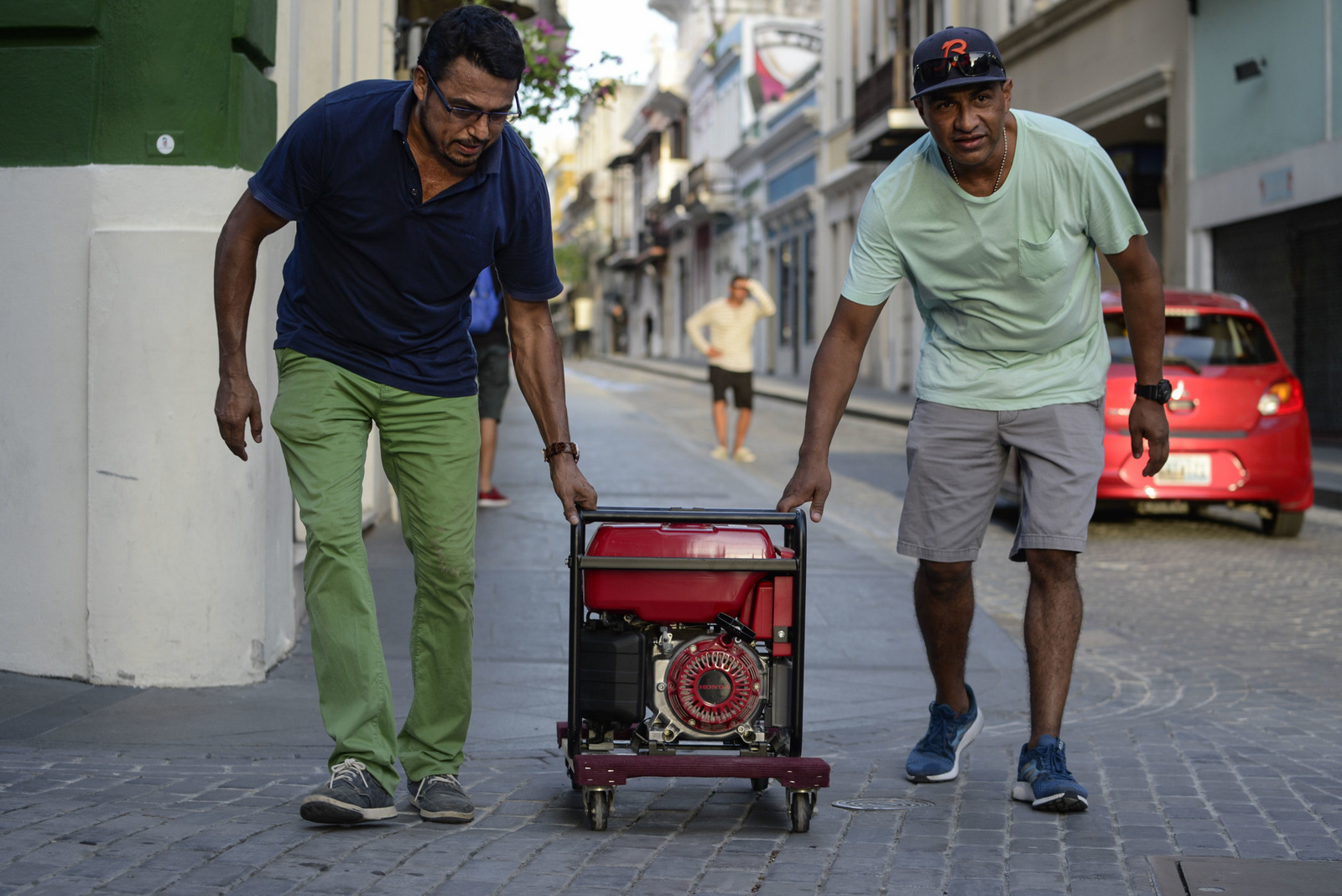 Men push a generator along Fortaleza street, one month after Hurricane Maria in San Juan, Puerto Rico. Maria roared across the island on Sept. 20 and after a month, only 30 percent of residents have power, Oct. 20, 2017 . (AP/Carlos Giusti)