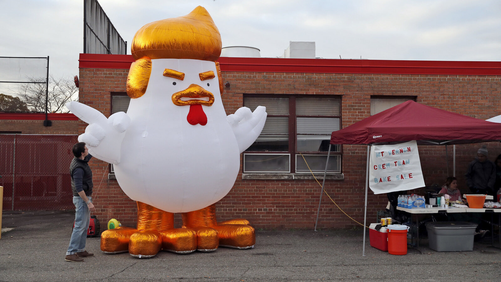 Ben Bostwick, a volunteer with the Northam campaign, adjusts an inflatable Trump chicken at a polling place, Nov. 7, 2017, in Alexandria, Va. Republican candidate for Virginia governor Ed Gillespie faces Democrat Lt. Gov. Ralph Northam in Tuesday's election. (AP/Alex Brandon)