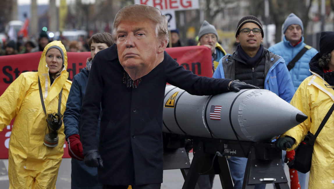 An anti-war protester wears a mask showing US President Donald Trump in Berlin, Germany, Saturday, Nov. 18, 2017 during a demonstration against nuclear weapons near the Brandenburg Gate. (AP/Michael Sohn)