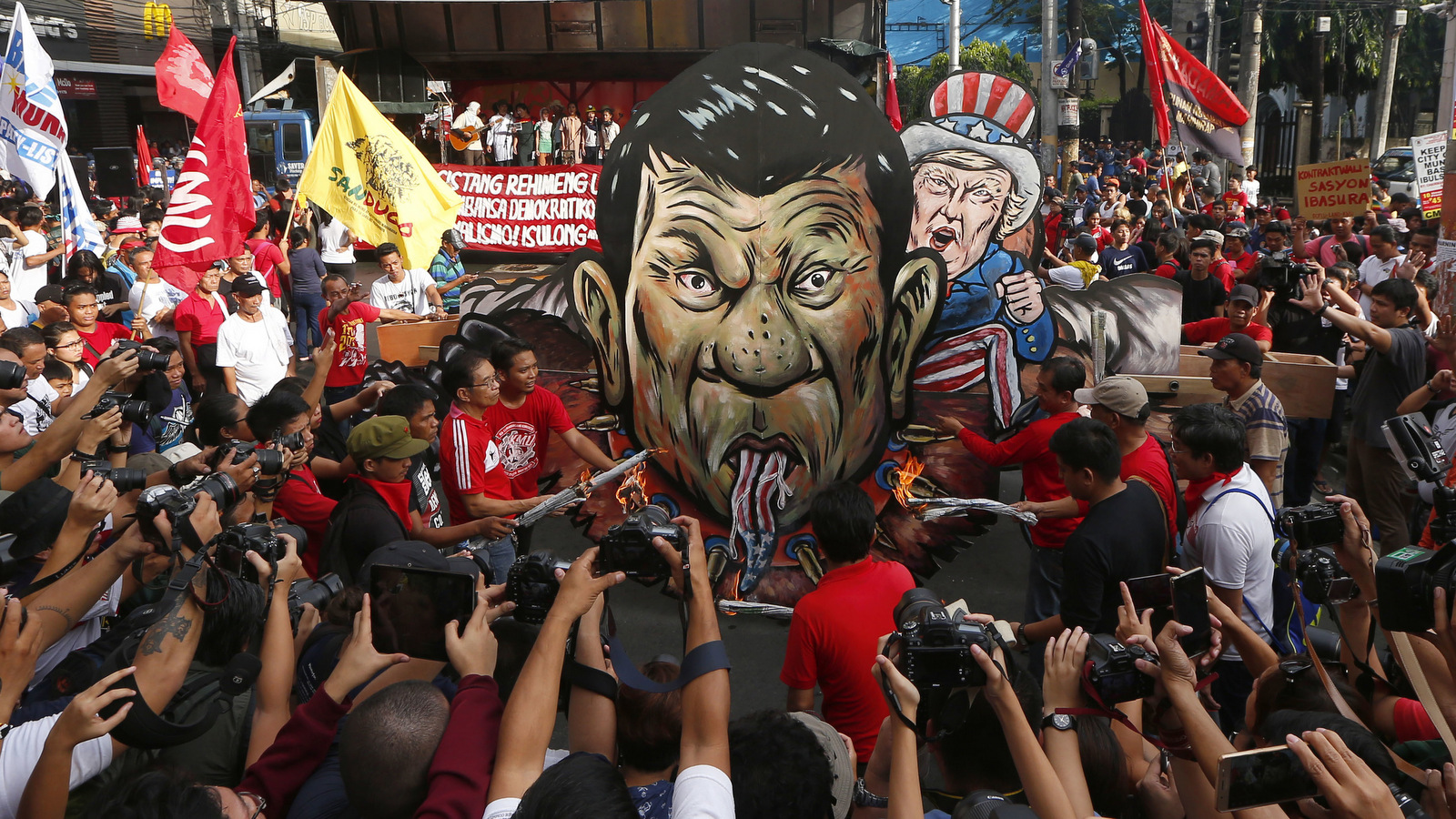 Protesters burn the effigies of President Rodrigo Duterte, left, and U.S. President Donald Trump during a rally near the Presidential Palace to mark the 154th birth anniversary of the country's revolutionary hero Andres Bonifacio, Nov. 30, 2017, in Manila, Philippines. (AP/Bullit Marquez)
