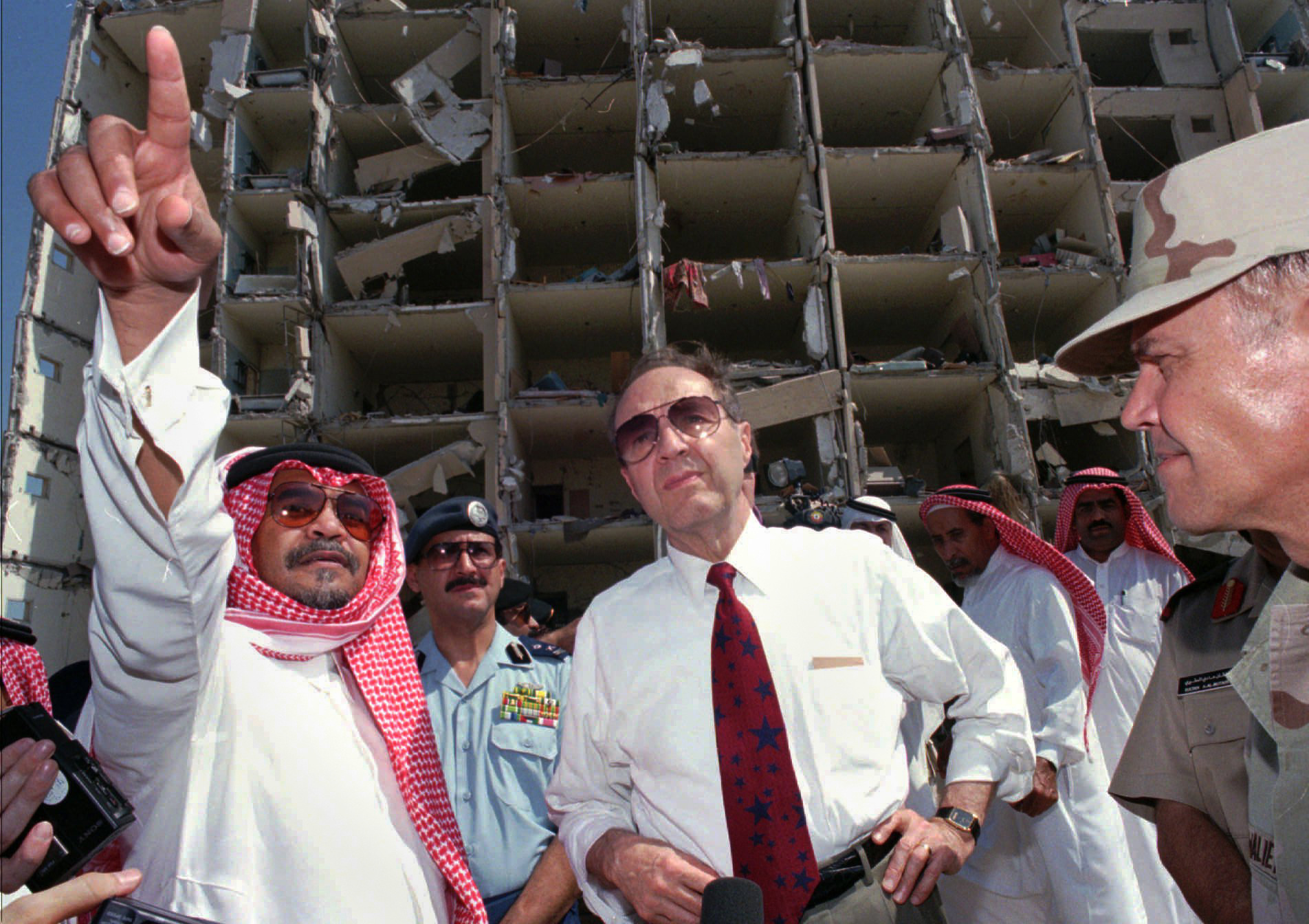 Defense Secretary William Perry, center, listens to then Saudi ambassador to the United States, Prince Bandar bin Sultan, left, at the blast site of the devastated Khobar Towers at a U.S. military base that killed 19 U.S. servicemen in Dhahran, Suadi Arabia, June 29, 1996. (AP/Saleh Rifai)