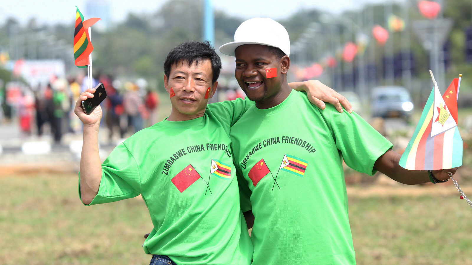 An unidentfied Chinese national and a Zimbabwean man hug while welcoming Chinese President Xi Jinping upon his arrival in Harare, Zimbabwe, Dec. 1. 2015.(AP/Tsvangirayi Mukwazhi)