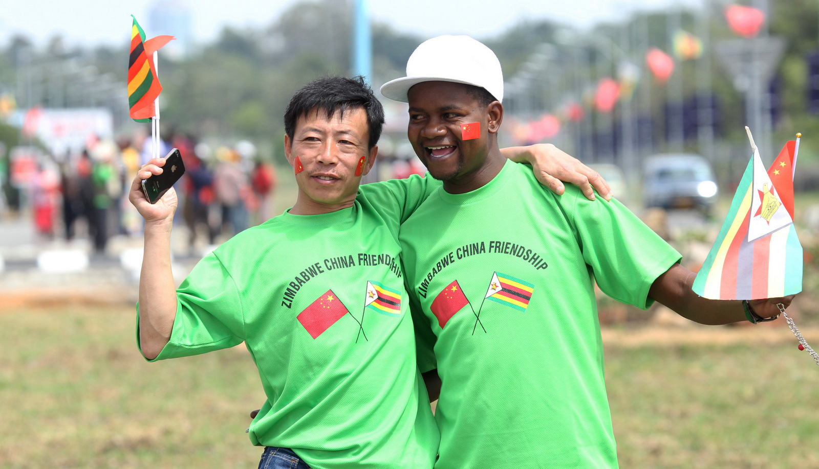 An unidentfied Chinese national and a Zimbabwean man hug while welcoming Chinese President Xi Jinping upon his arrival in Harare, Zimbabwe, Dec. 1. 2015.(AP/Tsvangirayi Mukwazhi)