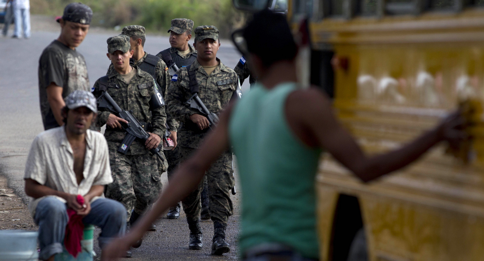 In this Nov. 16, 2013 photo, soldiers patrol at a bus terminal in Ulloa on the outskirts of Tegucigalpa, Honduras. Congress pushed through legislation creating a military police force to patrol the streets in place of the National Police. The program alarms human rights advocates concerned about potential abuses by the military acting in a civilian role, and the opposition says the presence of troops that supported a coup just four years ago is intimidating. (AP/Moises Castillo)