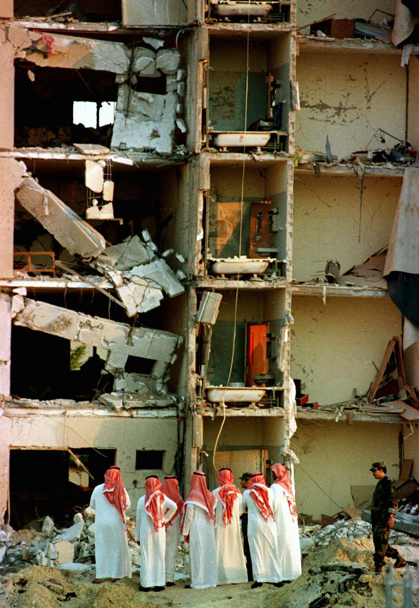 A group of Saudi officials investigate the site of the bomb-damaged Khobar Towers housing complex, at a U.S. military base in Dhahran, where 19 Americans were killed, and several hundred injured when a car bomb exploded. June 27, 1996. (AP/Greg Bos)