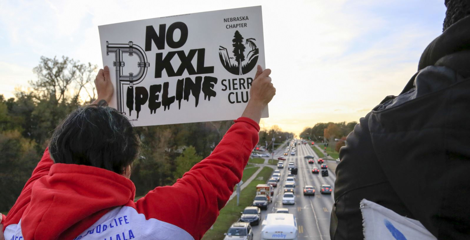 Opponents of the Keystone XL pipeline demonstrate on the Dodge Street pedestrian bridge during rush hour in Omaha, Neb., Wednesday, Nov. 1, 2017. The Nebraska Public Service Commission has until Nov. 23 to decide whether to approve or reject a proposed state route for the Keystone XL pipeline. (AP Photo/Nati Harnik)