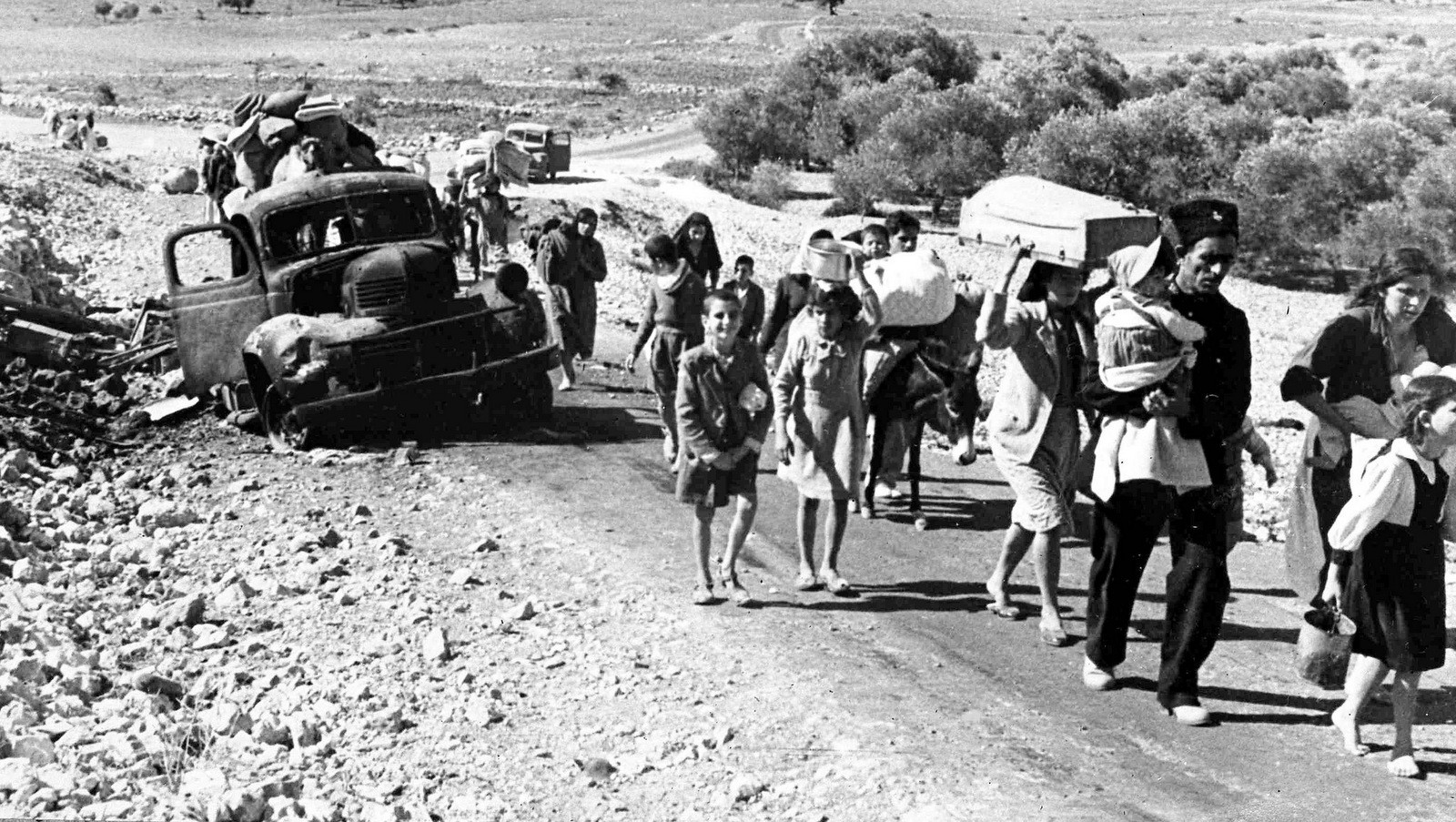 A group of struggling Arab refugees walk along the dusty road from Jerusalem to Lebanon, carrying their meager belongings with them, Nov. 9, 1948. The Arabs have been driven from their homes by Jewish attacks in Galilee. (AP/Pringle)