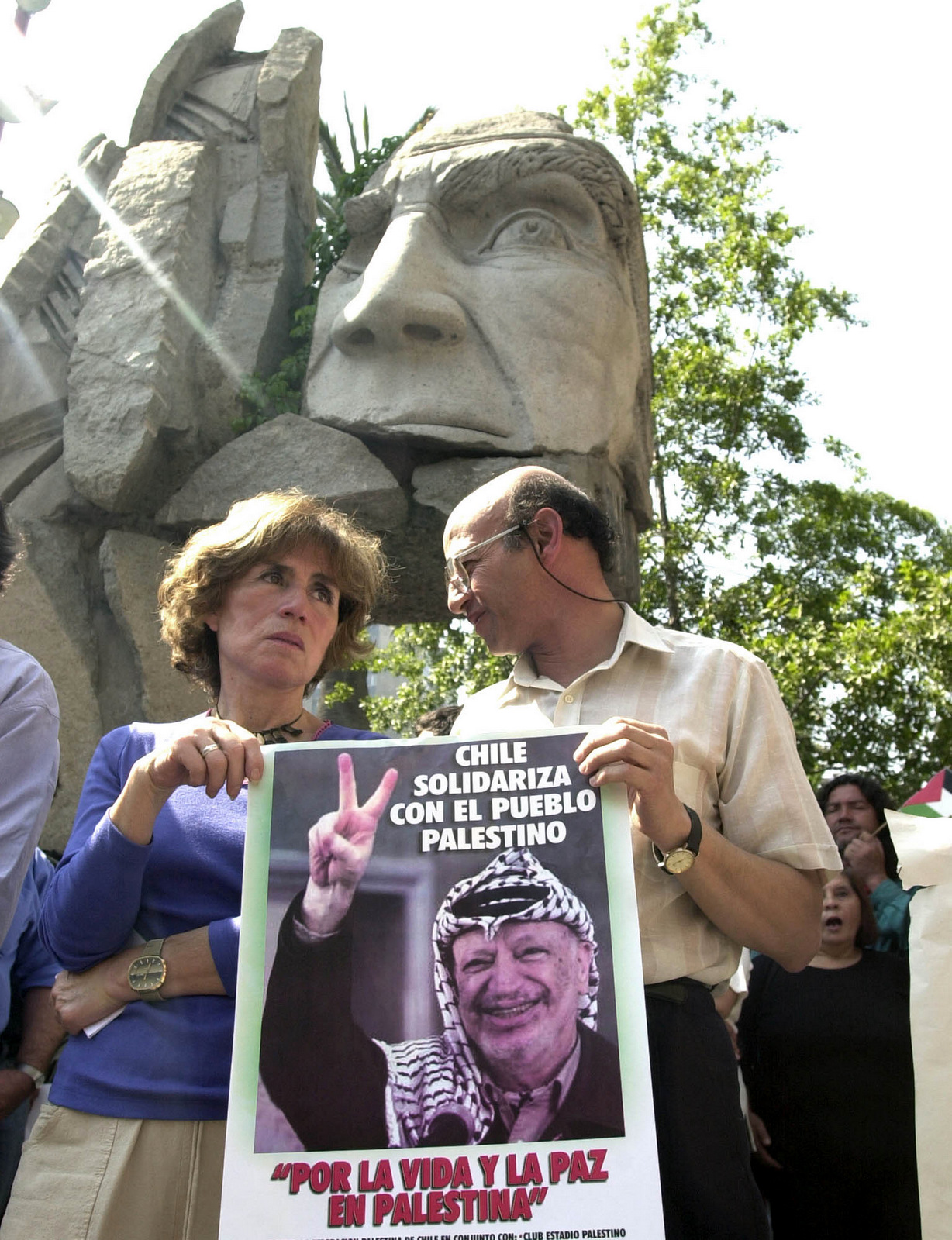 Gladys Marin, participtes in a peaceful protest in support of the Palestinian people in Santiago, Chile, April 3, 2002. The poster reads "Chile is in Solidarity with the Palestinian People," and "For Life and Peace in Palestine." In the background a monument is seen of a Chilean Indian. (AP/Santiago Llanquin)