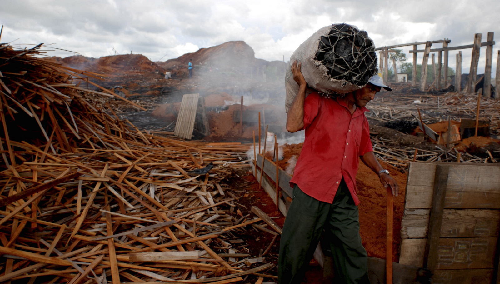 A man carries scrap wood from the Santo Antonio sawmill in Tailandia, Para state, Brazil, May 11, 2008 amidst a government crackdown on illegal logging. (AP/Renato Chalu)