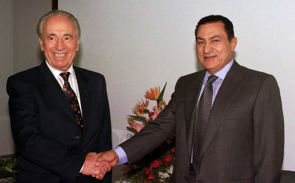 , Egyptian President Hosni Mubarak, right, shakes hands with former Israeli Prime Minister Shimon Peres at the Sharm el Sheikh resort in the Sinai peninsula for talks on the Middle East peace process, Oct. 1996. (AP/Mohamed El-Dakhakhny)
