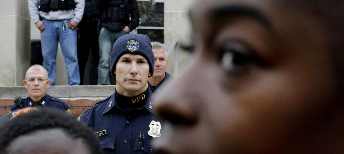 Members of the Baltimore Police Department stand guard outside the department's Western District police station during a protest in response to Freddie Gray's death in Baltimore. (AP/Patrick Semansky)