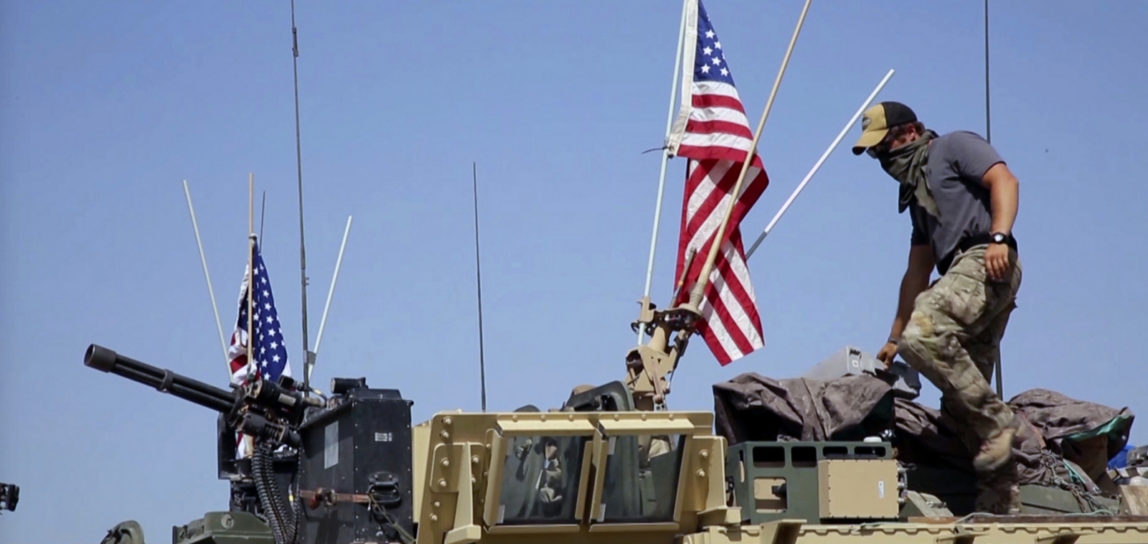 An American soldier standing on an armored vehicle in the northern village of Darbasiyah, Syria. U.S. moved troops and armored vehicles through several Syrian cities and towns on in a show of force. April. 29, 2017. (AP Photo via APTV)