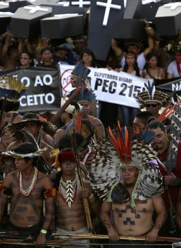 Indigenous protesters from various ethnic groups carry fake coffins representing indians killed over the demarcation of land, as they demand the demarcation of indigenous lands, outside the National Congress in Brasilia, Brazil. In May, Congress passed two measures that convert around 1.4 million acres of protected land, the vast majority of it in the Amazon, into areas open to logging, mining and agricultural use. (AP/Eraldo Peres)