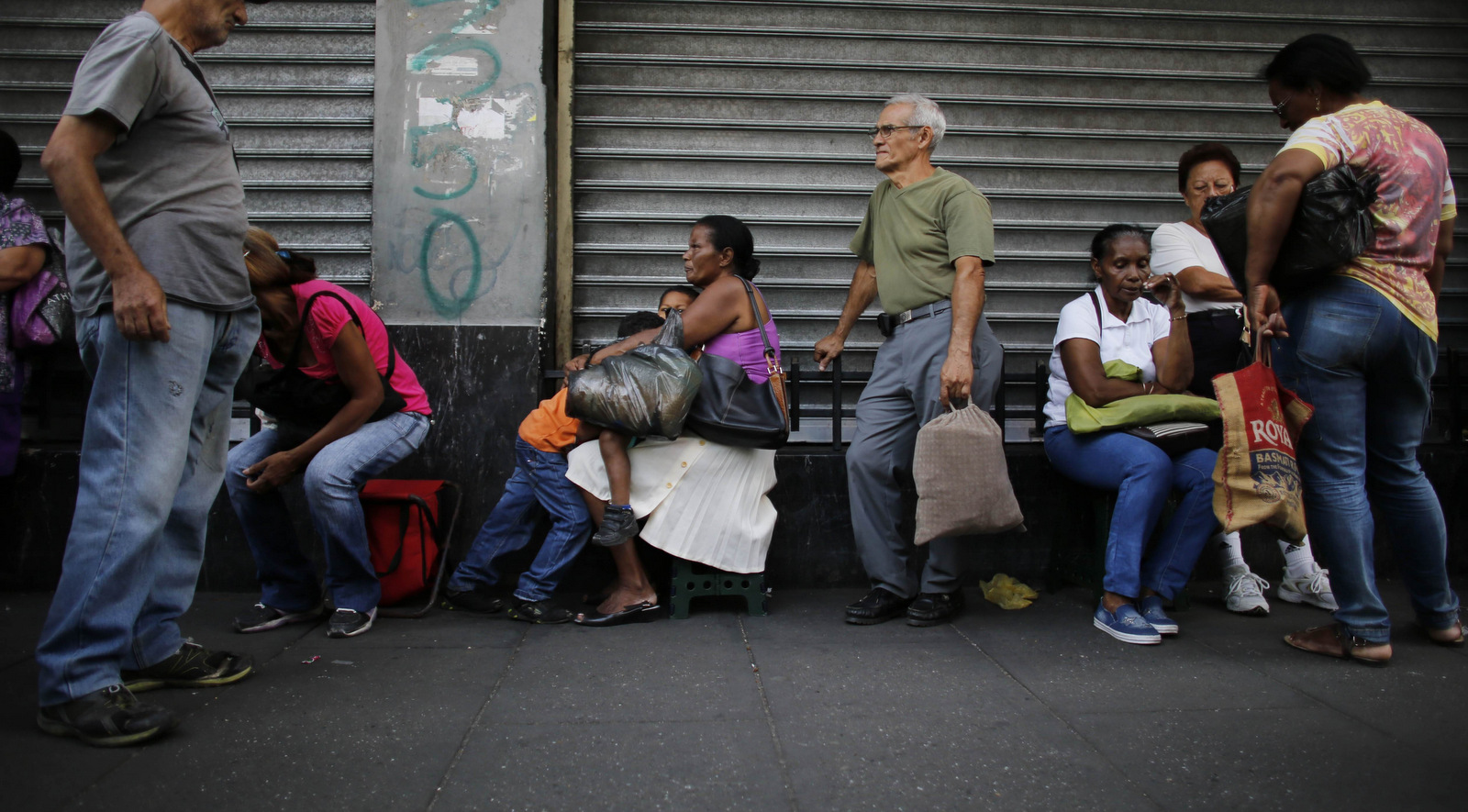 People wait outside a supermarket for subsidized products to arrive in Caracas, Venezuela amid crippling U.S. financial sanctions. Ariana Cubillos | AP