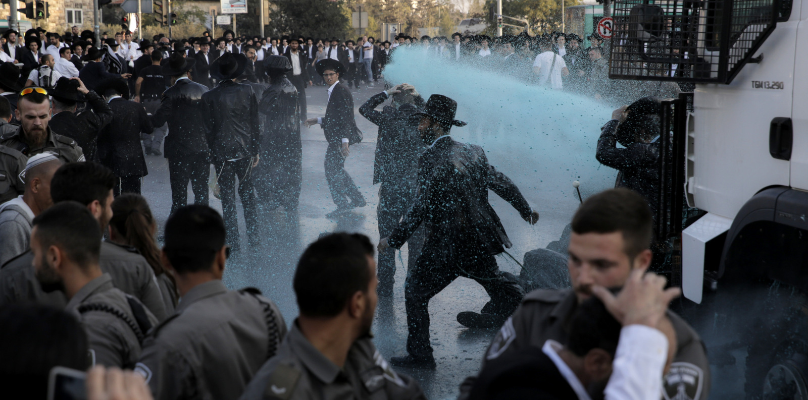 Israeli police officers spray colored water towards ultra Orthodox Jewish men during a protest against their enlistment in the army at the entrance to Jerusalem, Oct. 23, 2017. (AP/Sebastian Scheiner)