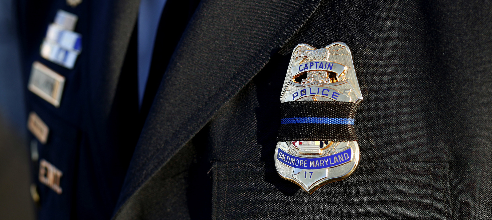 Baltimore Police Capt. Jarron Jackson wears a black mourning band across his badge before Baltimore Police Det. Sean Suiter's funeral at Mount Pleasant Church in Baltimore, Nov. 29, 2017. (AP/Patrick Semansky)