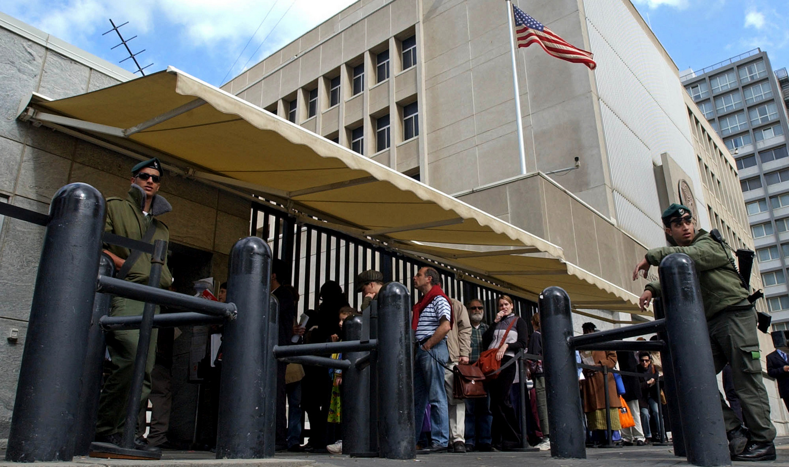 Israeli border policemen guards the U.S. Embassy in Tel Aviv as other Israelis line up for U.S. visas. (AP/Eitan Hess-Ashkenazi)