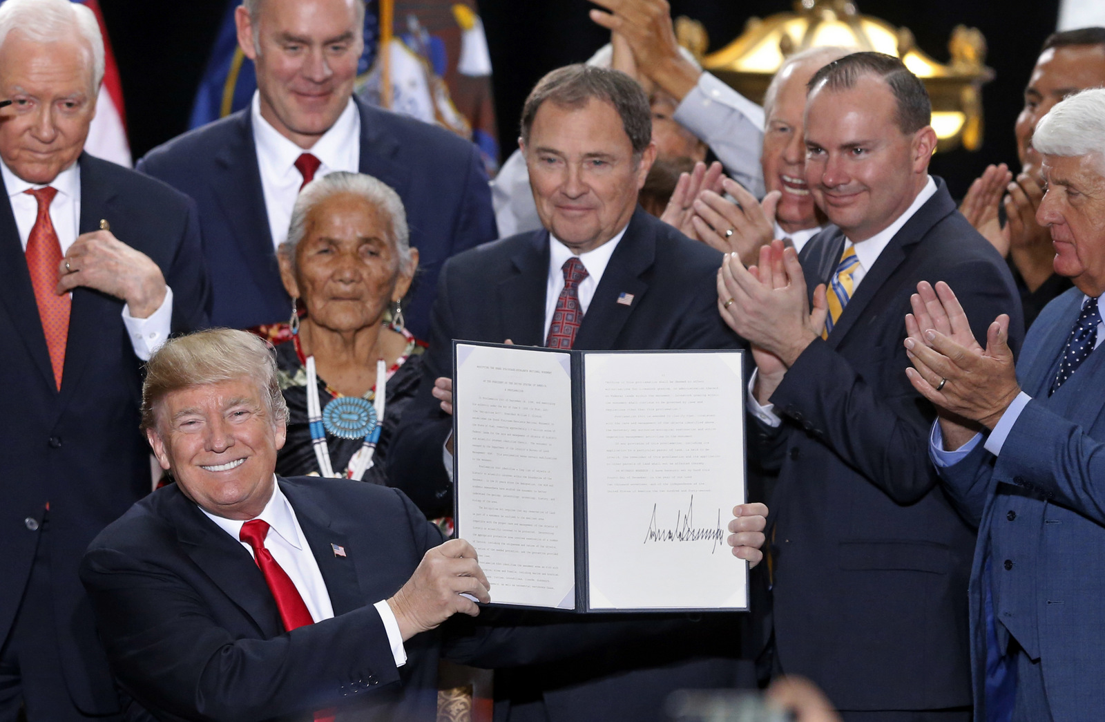 President Donald Trump holds up a signed proclamation to shrink the size of Bears Ears and Grand Staircase Escalante national monuments at the Utah State Capitol, Dec. 4, 2017, in Salt Lake City. (AP/Rick Bowmer)