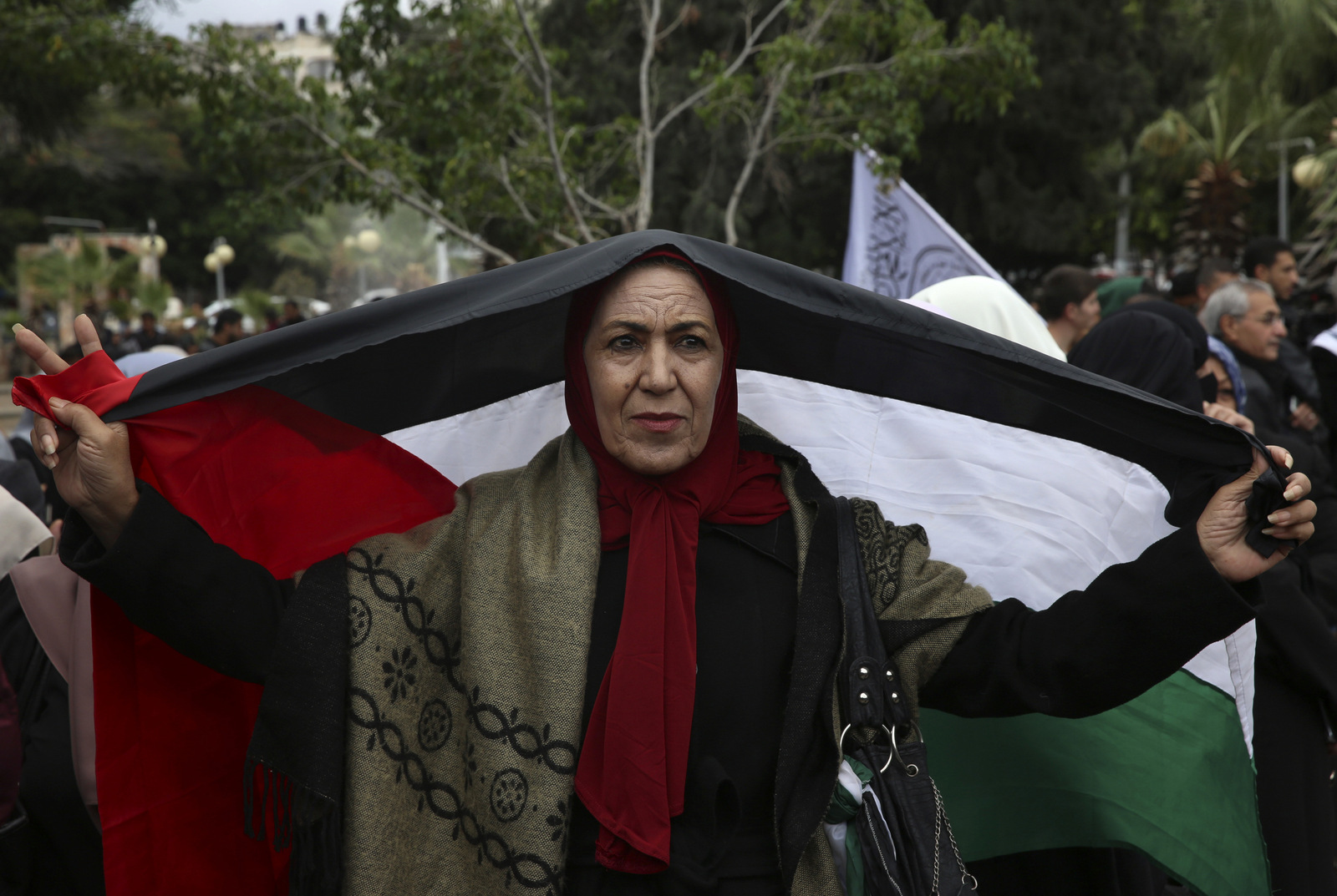 A women holds a Palestinian flag during a protest at the Unknown Soldier Square, in Gaza City, Wednesday, Dec. 6, 2017. (AP/Adel Hana)