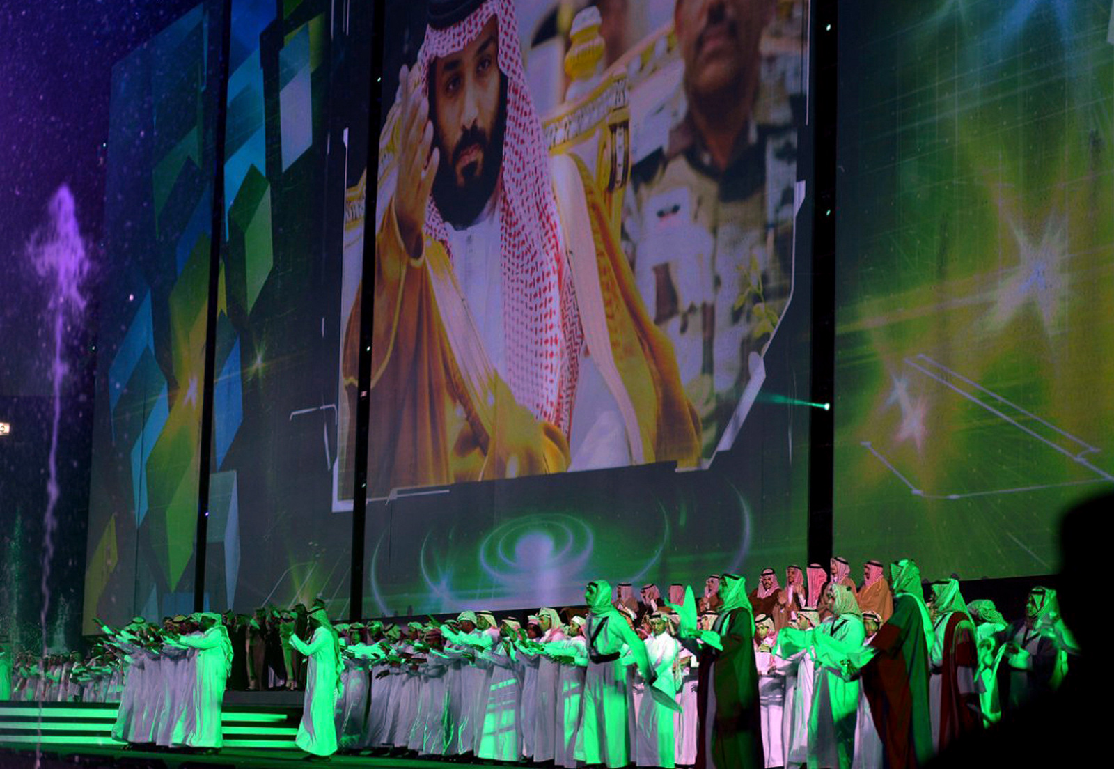 Saudi men perform under a giant screen showing an image of Saudi Crown Prince Mohammed Bin Salman during National Day ceremonies, at the King Fahd Stadium in Riyadh, Saudi Arabia. Saudi Arabia announced on Monday, Dec. 11, 2017 it will allow movie theaters to open in the conservative kingdom next year, for the first time in more than 35 years, in the latest social push by the country’s crown prince, Sept. 23, 2017. (Saudi Press Agency via AP)