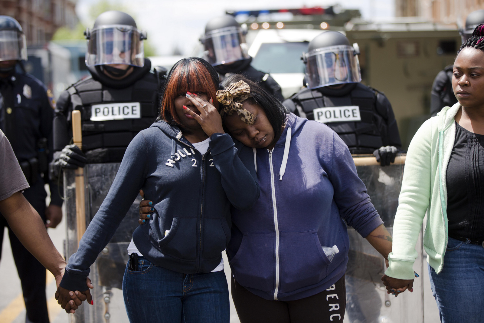 Baltimore residents embrace as people sing the hymn Amazing Grace, April 28, 2015, in Baltimore, in the aftermath of protests following the funeral for Freddie Gray, who died in police custody. (AP/Matt Rourke)