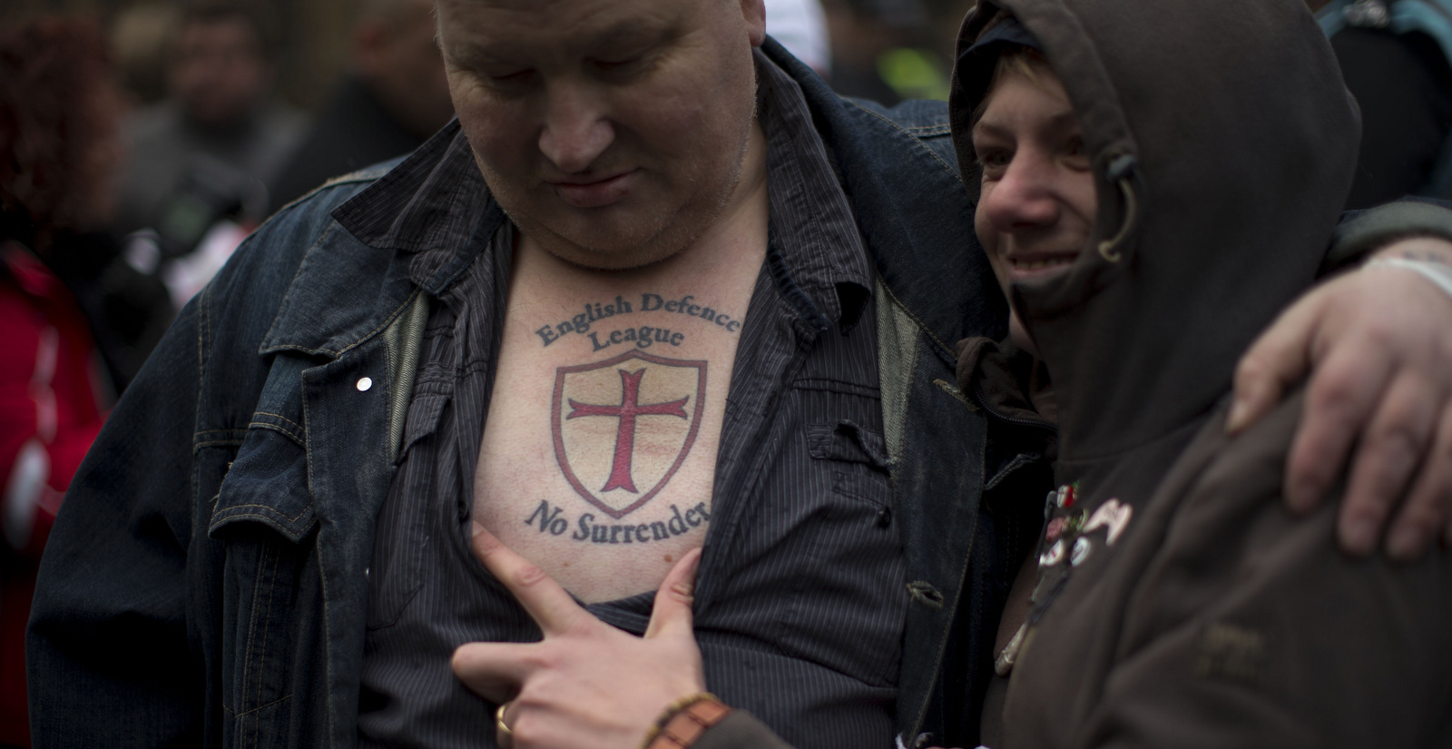 A member of the English Defence League far right group has his tattoo displayed for media cameras during a protest outside the Houses of Parliament in London, Oct. 27, 2012. (AP/Matt Dunham)