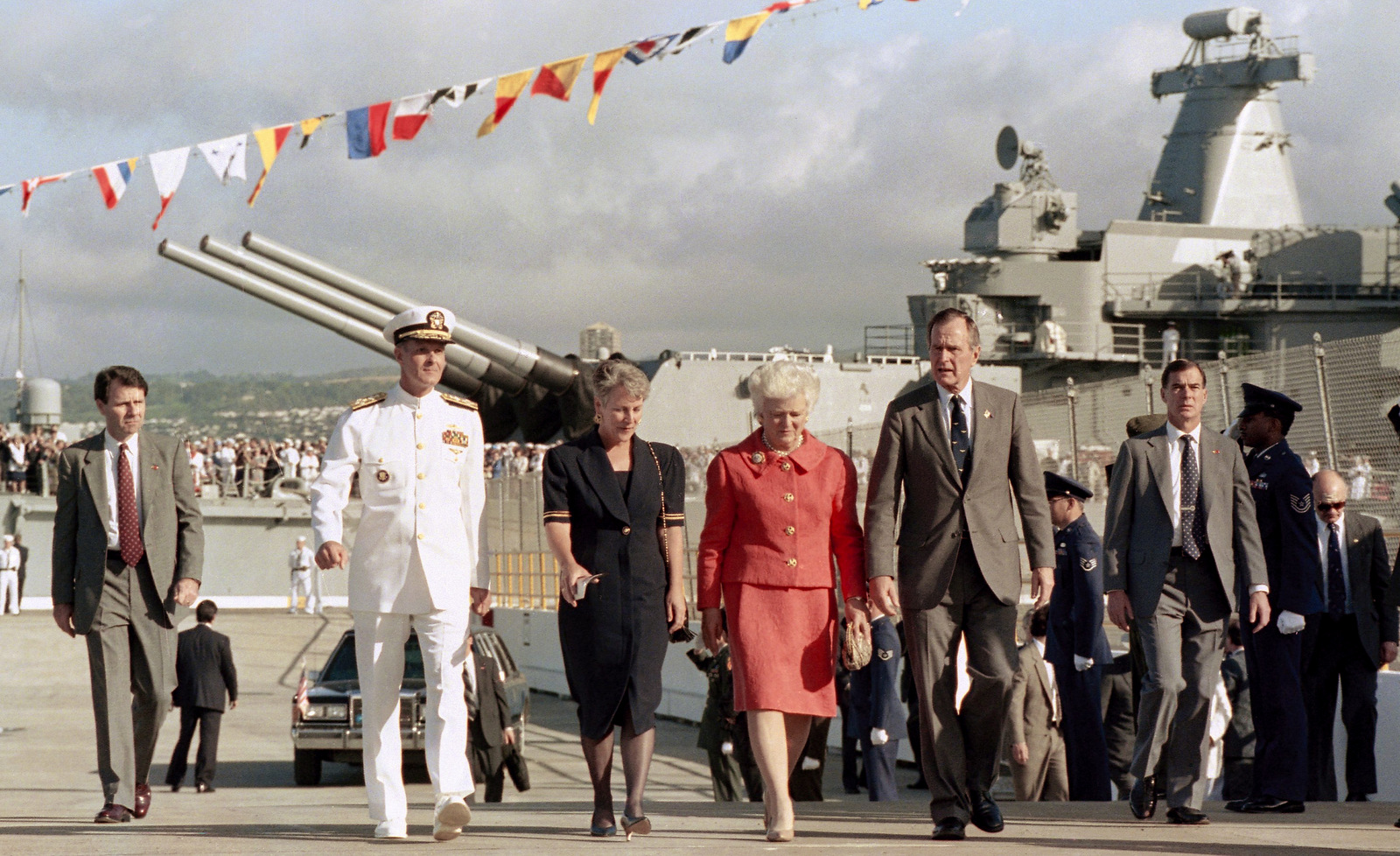 President George H.W. Bush and Mrs. Barbara Bush are escorted along a Navy pier past the battleship USS Missouri by Admiral Charles Larson, Commander of Pacific Forces, and his wife Sally, in Pearl Harbor, Hawaii on Dec. 7, 1991. Bush was walking to a podium to address Pearl Harbor survivors and military personnel. (AP/Ron Edmonds)