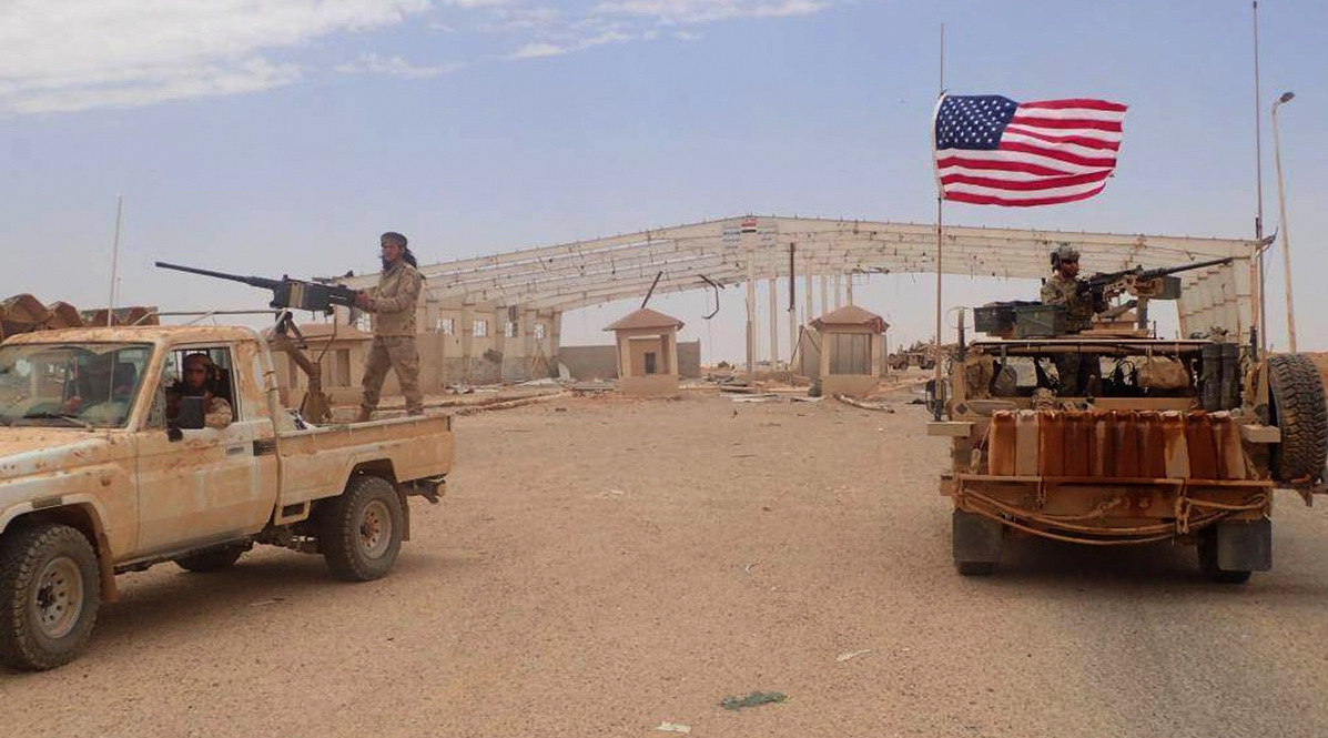 A U.S.-backed anti-government fighter mans a heavy automatic machine gun, left, next to an American soldier as they take their positions at Tanf, a border crossing between Syria and Iraq (Hammurabiâ€™s Justice News/AP)