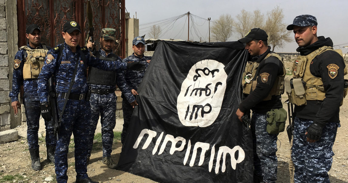 Iraq's federal police forces celebrate as they hold a flag of the Islamic State group they captured after regaining control of Gawsaq neighborhood in the western side of Mosul, Iraq, Feb. 27. 2017. (AP/Mohammed Saad)