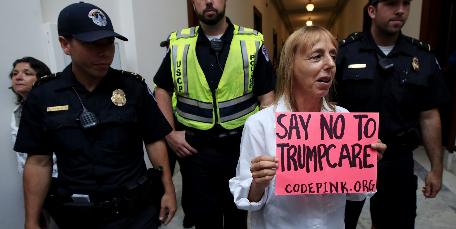 CodePink co-founder Medea Benjamin walks with other protesters against the Republican health care bill as they were escorted by the U.S. Capitol Police officers away from the office of Senate Majority Leader Mitch McConnell of Ky., July 17, 2017, on Capitol Hill in Washington. (AP/Manuel Balce Ceneta)