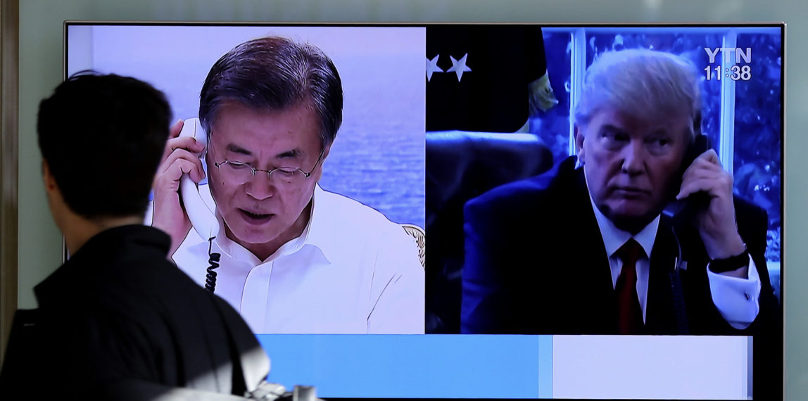 A man walks by a TV screen showing a local news program reporting about North Korea's missile launch with an images of U.S. President Donald Trump and South Korean President Moon Jae-in at the Seoul Railway Station in Seoul, South Korea, Dec. 1, 2017. (AP/Lee Jin-man)