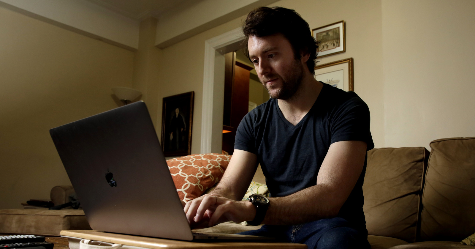 Michael Weiss works on his laptop in his apartment on New York's Upper West Side, Dec. 8, 2017. (AP/Richard Drew)