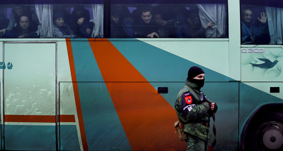 A separatist rebel guards a bus carrying prisoners who were released by the Ukrainian authorities in Horlivka, eastern Ukraine, Dec. 27, 2017. (AP Photo)