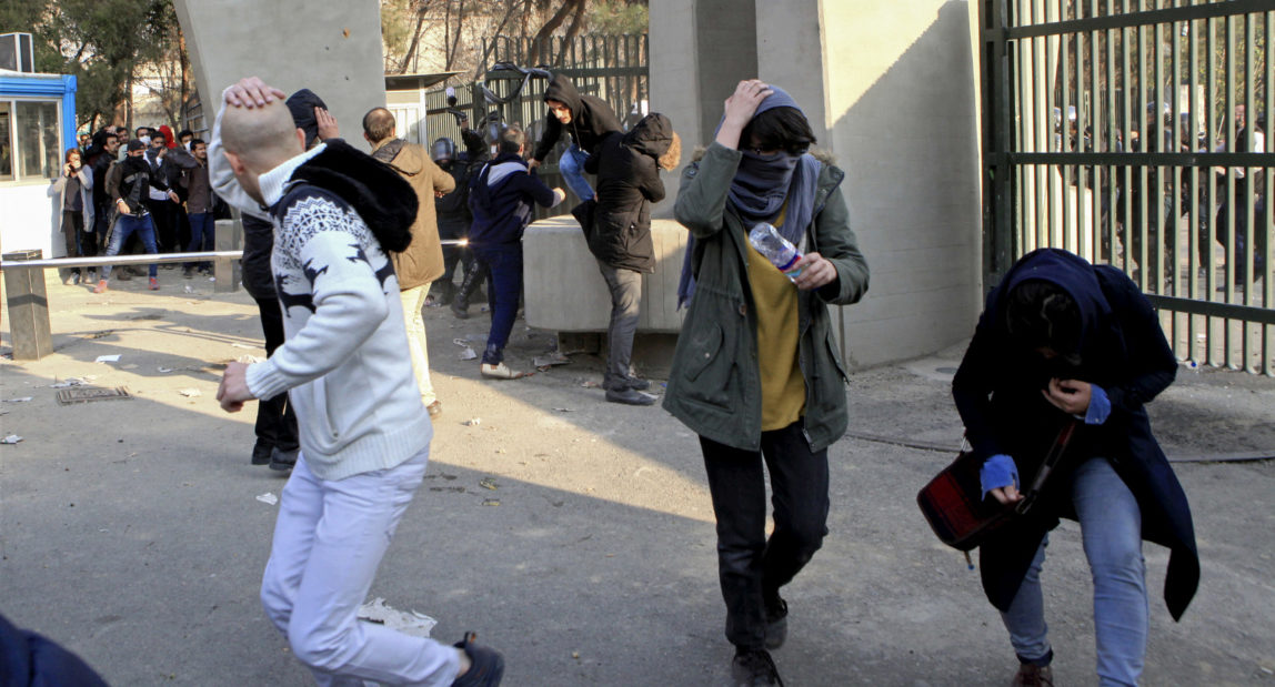 University students run away from police during an anti-government protest inside Tehran University, in Tehran, Iran, Dec. 30, 2017. (AP Photo)