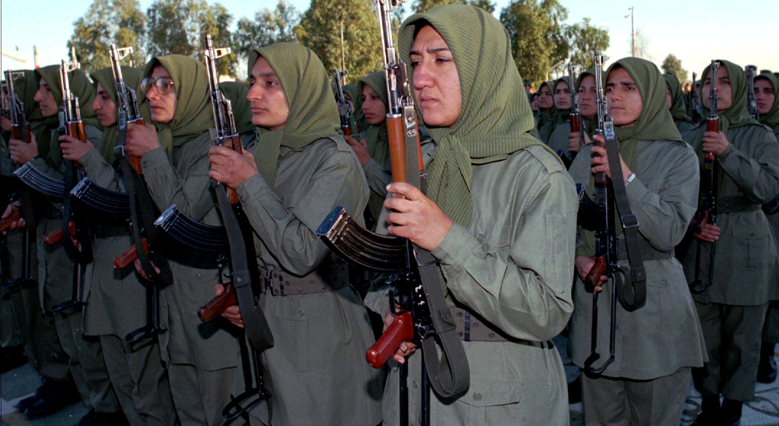 Female fighters armed with AK-47s in the National Liberation Army of Iran, a militia formed through cooperation between the MEK and Saddam Hussein, stand at attention during a flag ceremony at Camp Ashraf, Jan 29 1997, northeast of the Iraqi capital Baghdad (AP/Jassim Mohammmed)