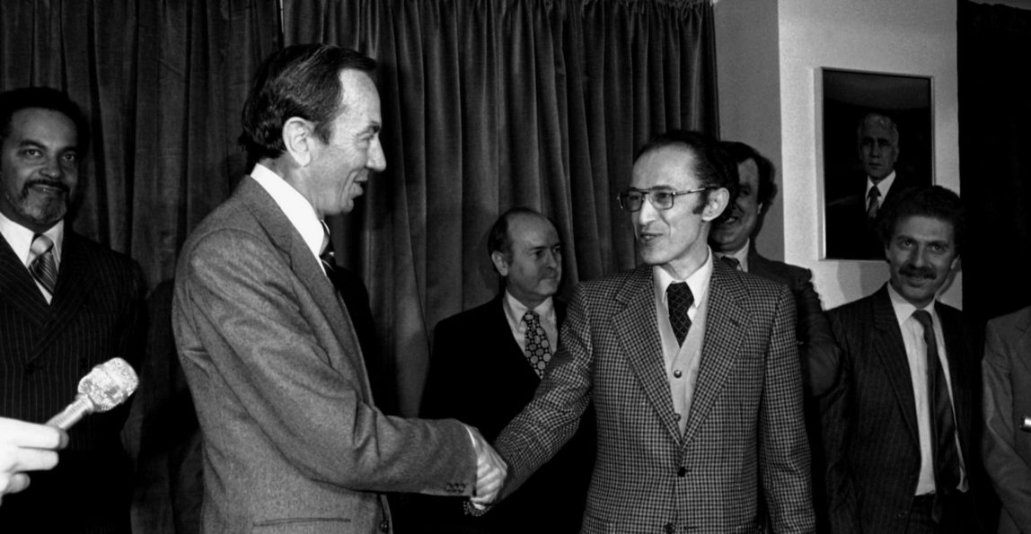U.S. Deputy Secretary of State Warren Christopher, (left), shakes the hand of Algerian Foreign Minister Mohamed Ben Yahia, after the signing of the formal agreement between the United States and Iran to Free the American hostages, at the Foreign Ministry in Algiers, on Jan. 19, 1981. (AP Photo)