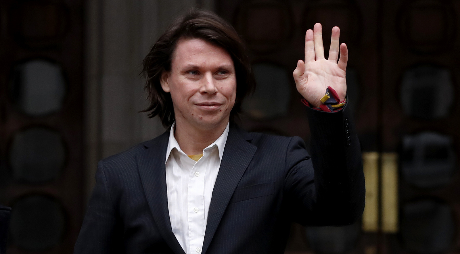 Lauri Love waves to supporters outside The Royal Courts of Justice in London, Monday, Feb. 5, 2018. The ruling in Lauri Love's appeal against extradition to the United States, where he faces solitary confinement and a potential 99 year prison sentence, will be handed down on Monday Feb. 5 at the Royal Courts of Justice. (AP Photo/Kirsty Wigglesworth)