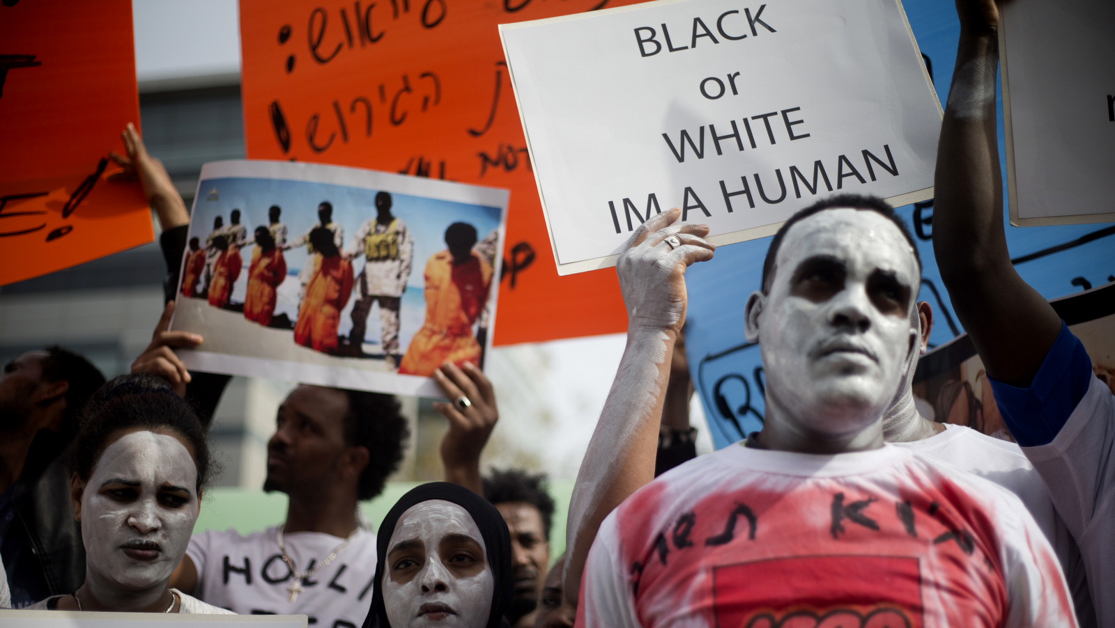 African migrants hold signs during a protest in front of Rwanda embassy in Herzeliya, Wednesday, Feb. 7, 2018. African asylum seekers are protesting an Israeli plan to deport them.Israel says thousands of migrants have 60 days to accept an offer to leave the country for an unnamed African destination -- known to be Rwanda -- in exchange for $3,500 and a plane ticket. Those who don't by April 1 will be incarcerated indefinitely. (AP Photo/Ariel Schalit)