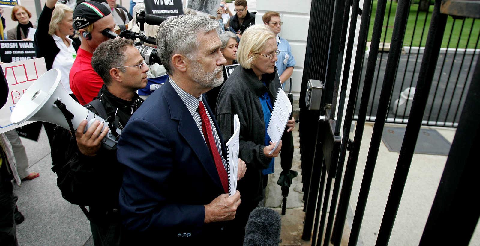 Ray McGovern, center, and Ann Wright, right, with the Bush Crimes Commission try to deliver to the White House in Washington, Sept. 13, 2006, to President Bush. The citizens' Commission of Inquiry concluded its year-long investigation into whether the Bush administration has committed war crimes and crimes against humanity. White House officers refused the item and ask them to mail it to the White House. (AP/Ron Edmonds)